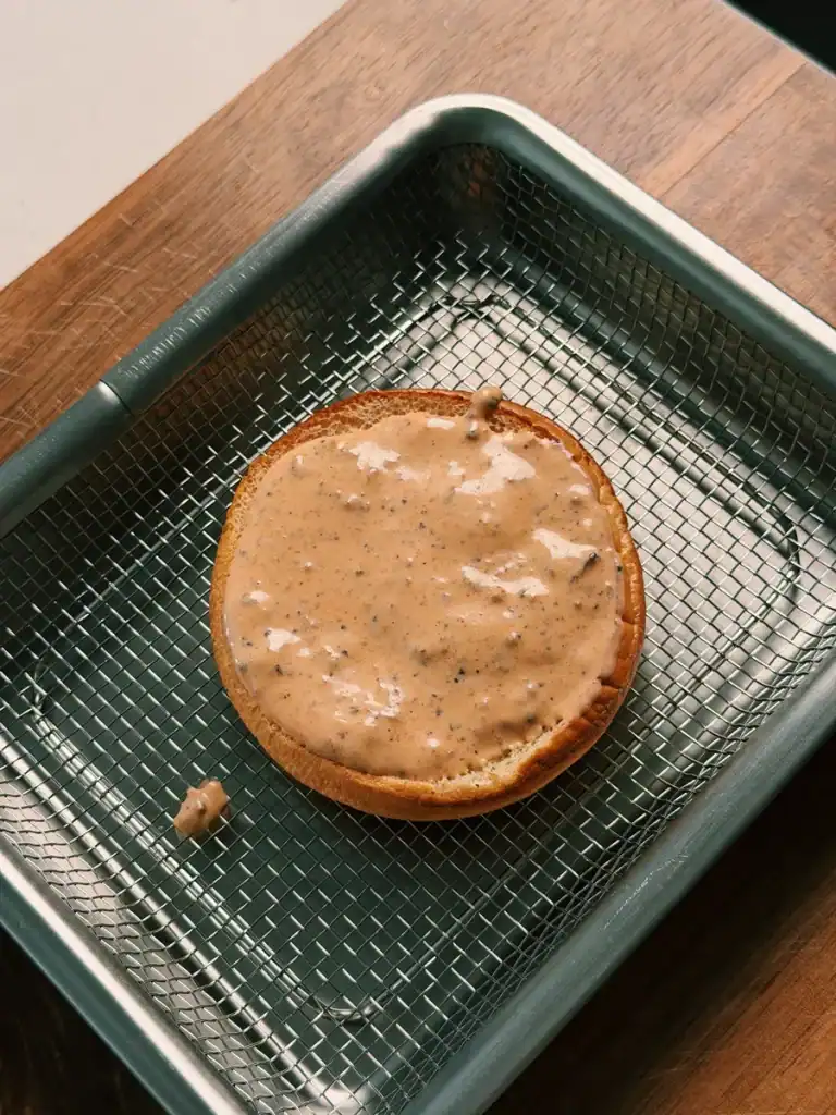A potato bun for smash burger layered with homemade black pepper burger sauce
