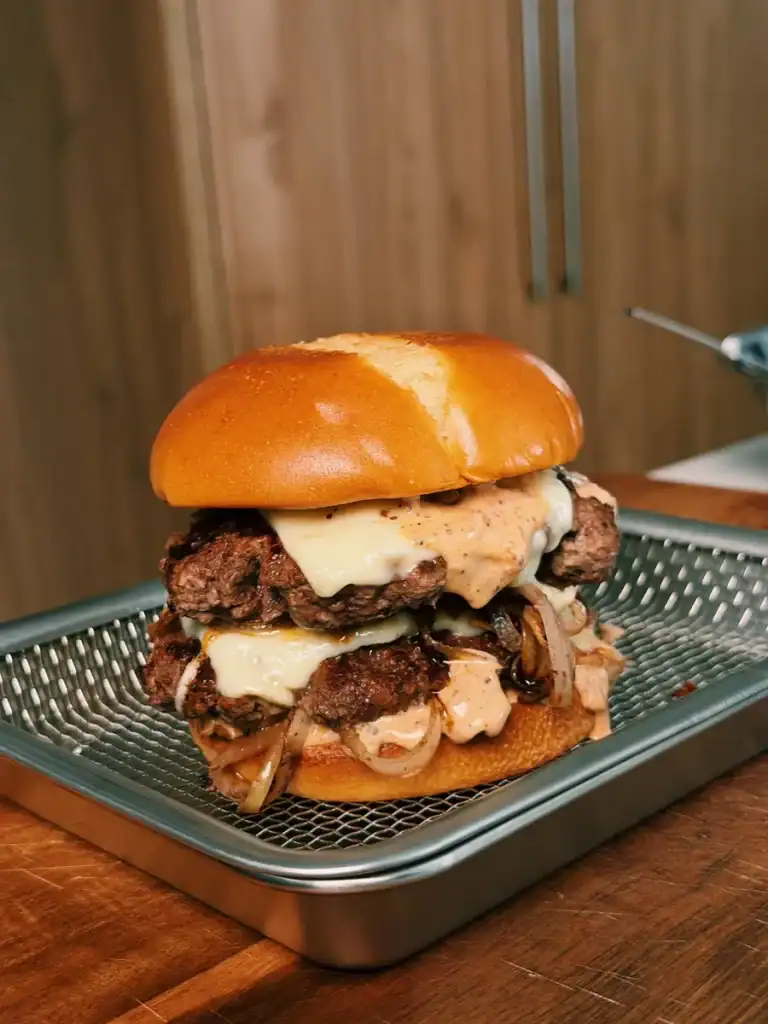 A double cheesy smash burger with homemade black pepper burger sauce