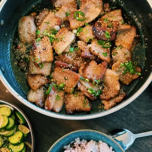 Korean-Inspired Soy Glazed POrk Belly with a bowl of rice and cucumber salad