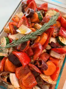Fresh, seasoned vegetable topped with a sprig of fresh rosemary before oven roasting to make Roasted Veggie Soup