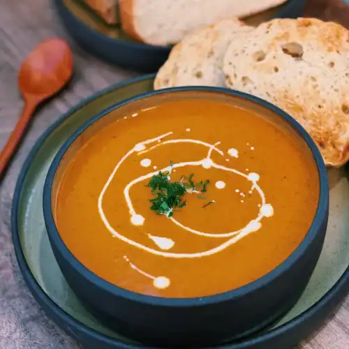Oven Roasted Vegetable Soup made with 7 different vegetables topped with cream. Served with toasted bread.