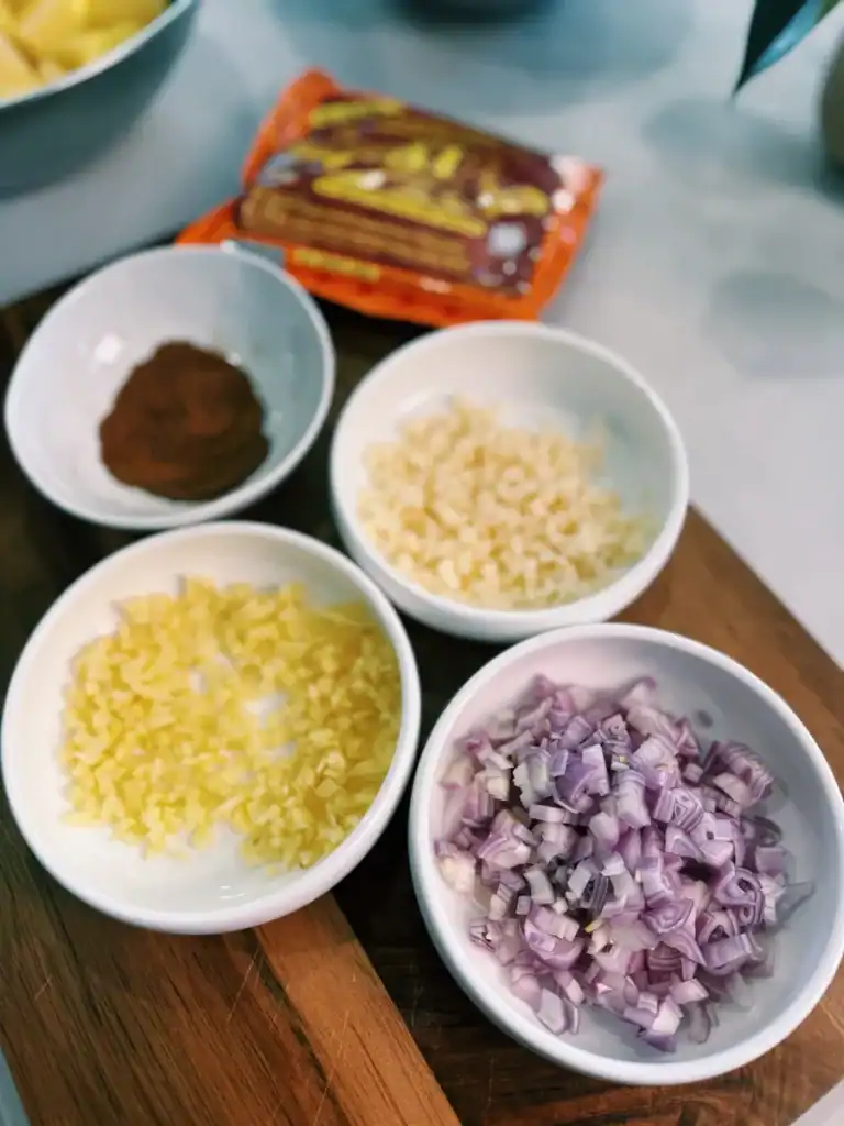 Aromatics for Singaporean Chicken Curry, including shallots, garlic, ginger, and chili