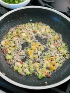 Sautéing chopped green onions in bacon fat for 10 Minute Spicy Creamy Bacon Udon