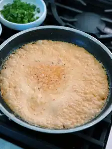 Making a spicy cream sauce for Spicy Creamy Bacon Udon with heavy cream, gochujang, gochugaru, and black pepper.