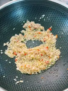 Stir Frying ginger, garlic, shallots, and chili in oil for Spicy Thai Basil Chicken Noodle Stir Fry