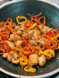 Sautéing bell pepper and chicken thigh chunks for Spicy Thai Basil Chicken Noodle Stir Fry