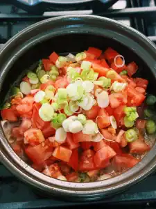 Saute tomatoes and green onions to make the tomato beef noodle soup base