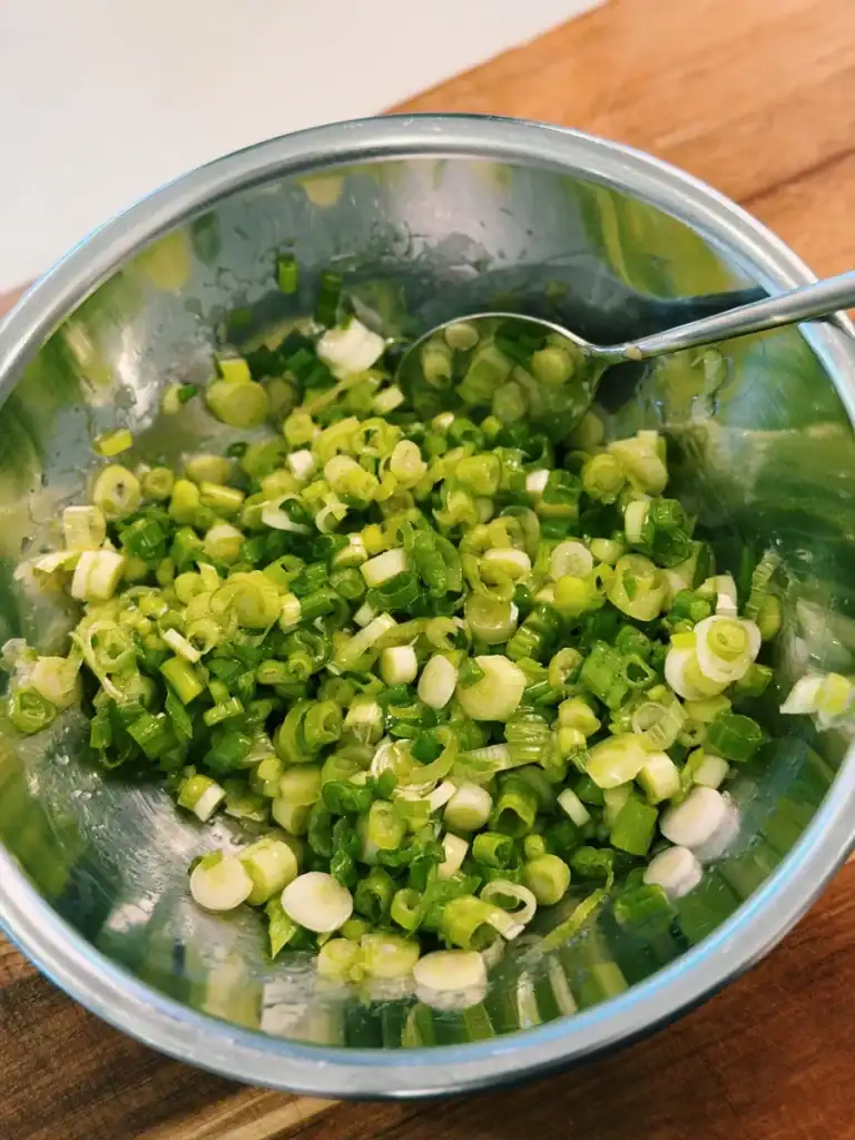 Mixing chopped green onions, olive oil, and salt into a scallion oil mix for Scallion Focaccia. 