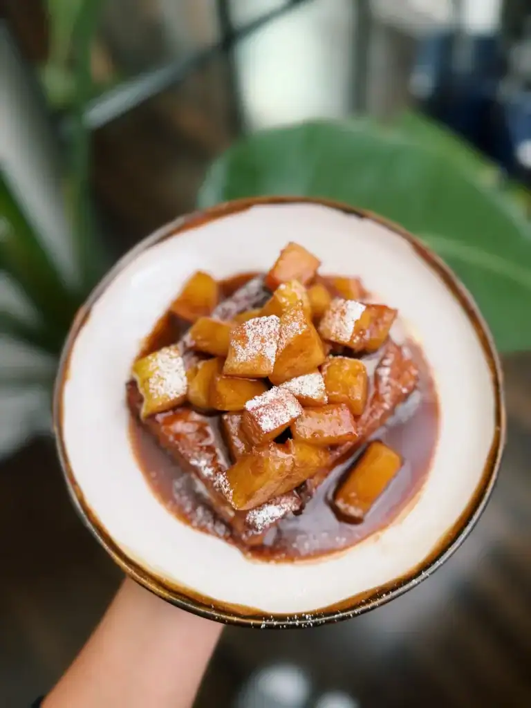 A plate of Hong Kong Style French Toast drizzled with cinnamon apple sauce and dusted with powdered sugar