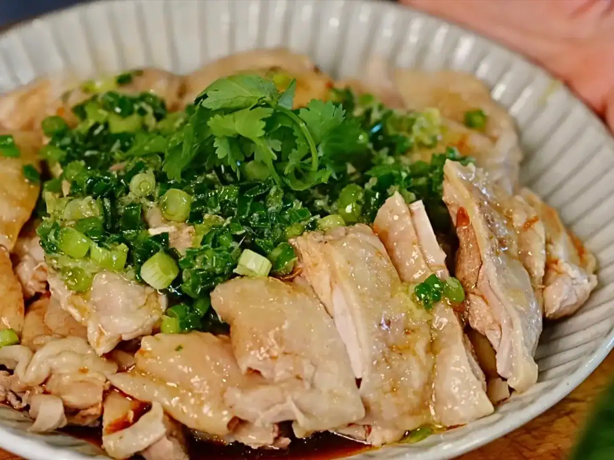 Scallion Ginger Poached Chicken topped with kai dong shallot scallion sauce, chopped cilantro, and ginger scallion oil