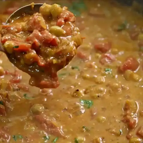 A scoop of Coconut Chickpea Curry from the pot while it’s simmering