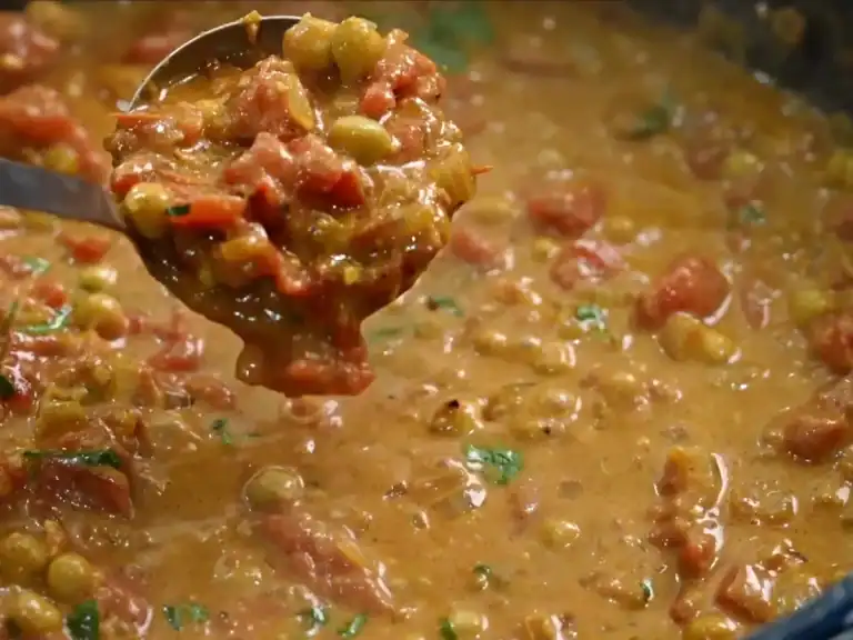 A scoop of Coconut Chickpea Curry from the pot while it’s simmering