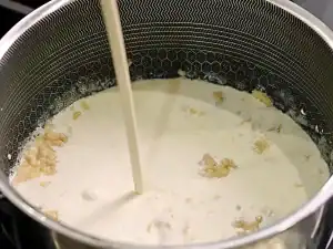 Mixing roux and cream for cheesy cauliflower bake