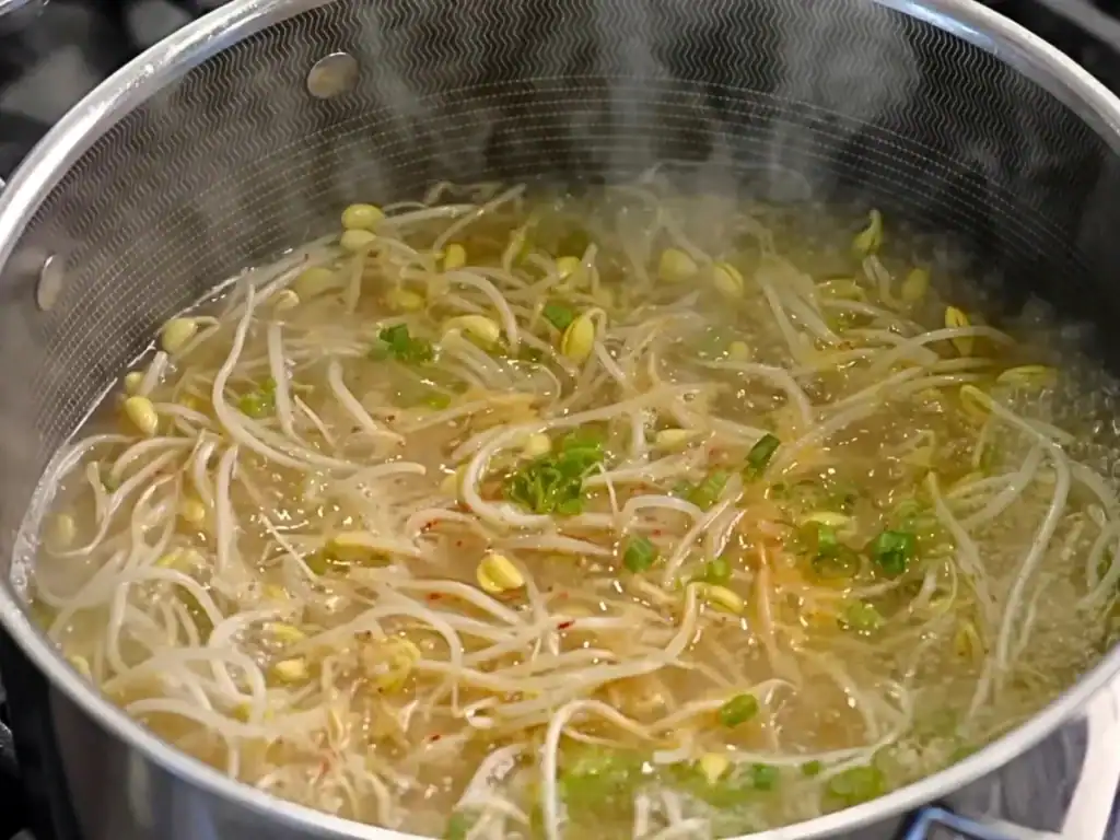 Adding scallions to finish Korean Bean Sprout Soup