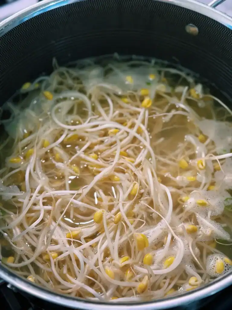 Adding gochugaru to simmering Korean Bean Sprout Soup