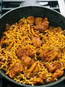 Adding Noodles in the pan to Korean Spicy Chicken Noodle