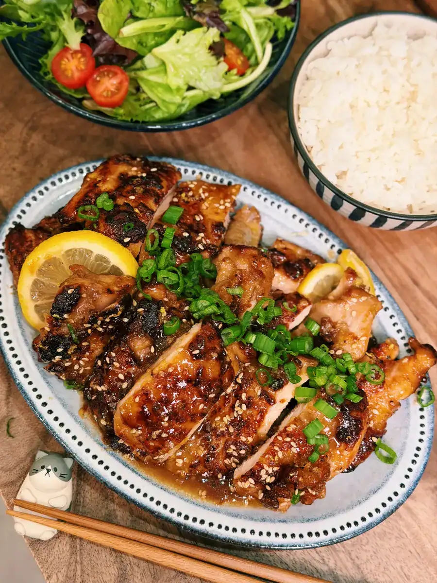Lemon Honey Glazed Chicken Thighs served with rice and ganirshed with cilantro and slices of lemon
