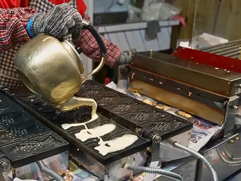 Pouring Batter into a mold for Bungeoppang in Mangwon Market in Seoul