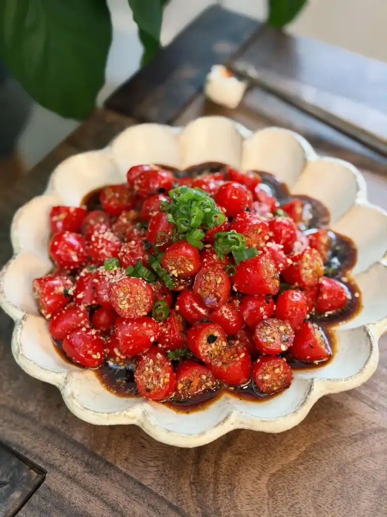 Sesame Yuzu Cherry Tomato Salad topped with chopped green onions.