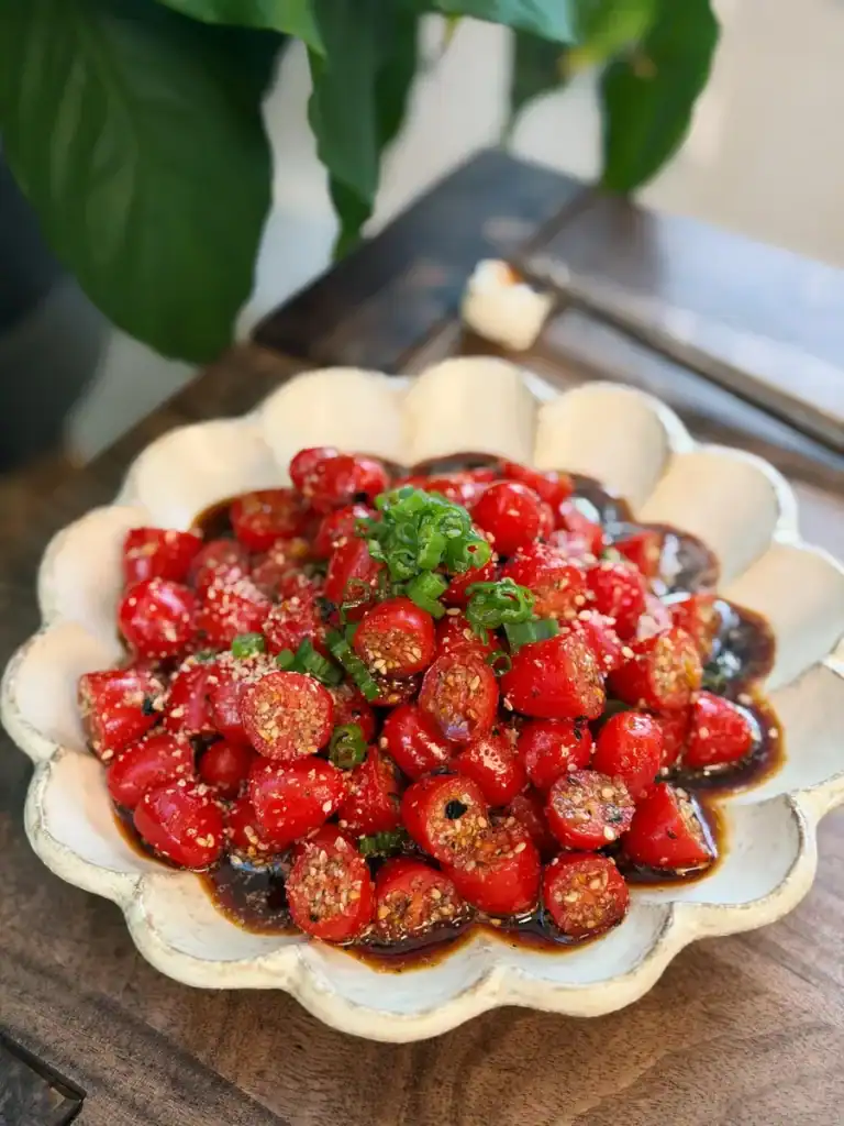 Sesame Yuzu Cherry Tomato Salad topped with chopped green onions.