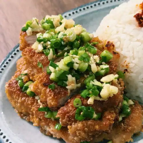 Crispy Taiwanese Scallion Pork Chop served with rice, cut into slices and topped with scallion sauce