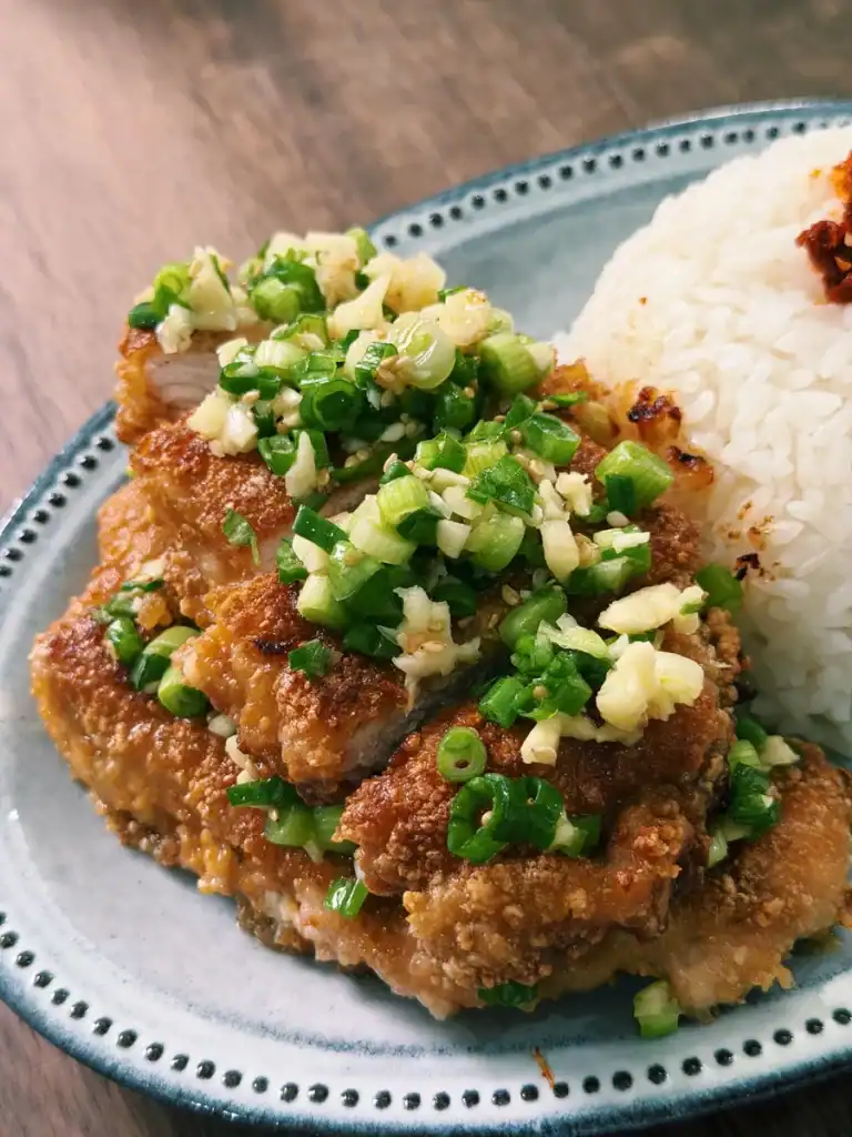 Crispy Taiwanese Scallion Pork Chop served with rice, cut into slices and topped with scallion sauce