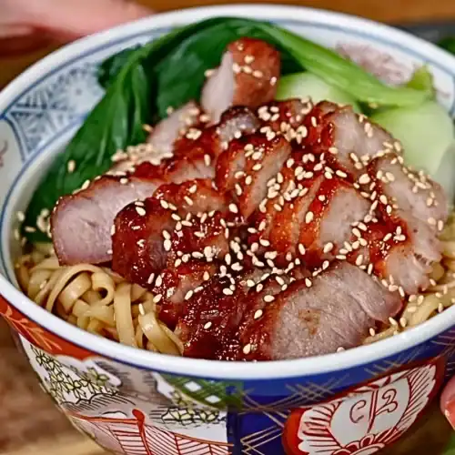 A bowl of BBQ Pork Lo Mein with Bok choy, Air Fryer BBQ Pork, and sweet-savory dried mixed noodles