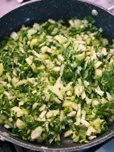 Sautéing chopped bok choy before adding them into the Shanghai Cai Fan Vegetable Rice with salted meat