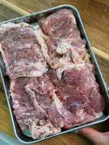 Seasoning chicken thighs with salt and pepper after drying with paper towels for Hawaiian Shoyu Chicken