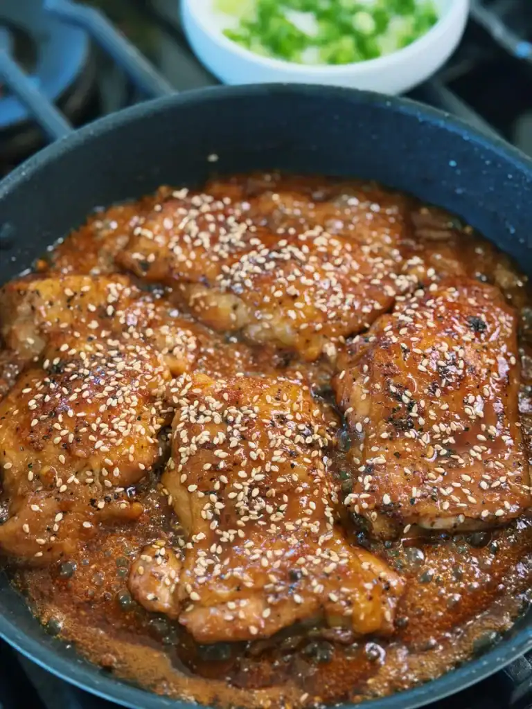 Simmered Shoyu Chicken in the pan garnished with sesame seeds 