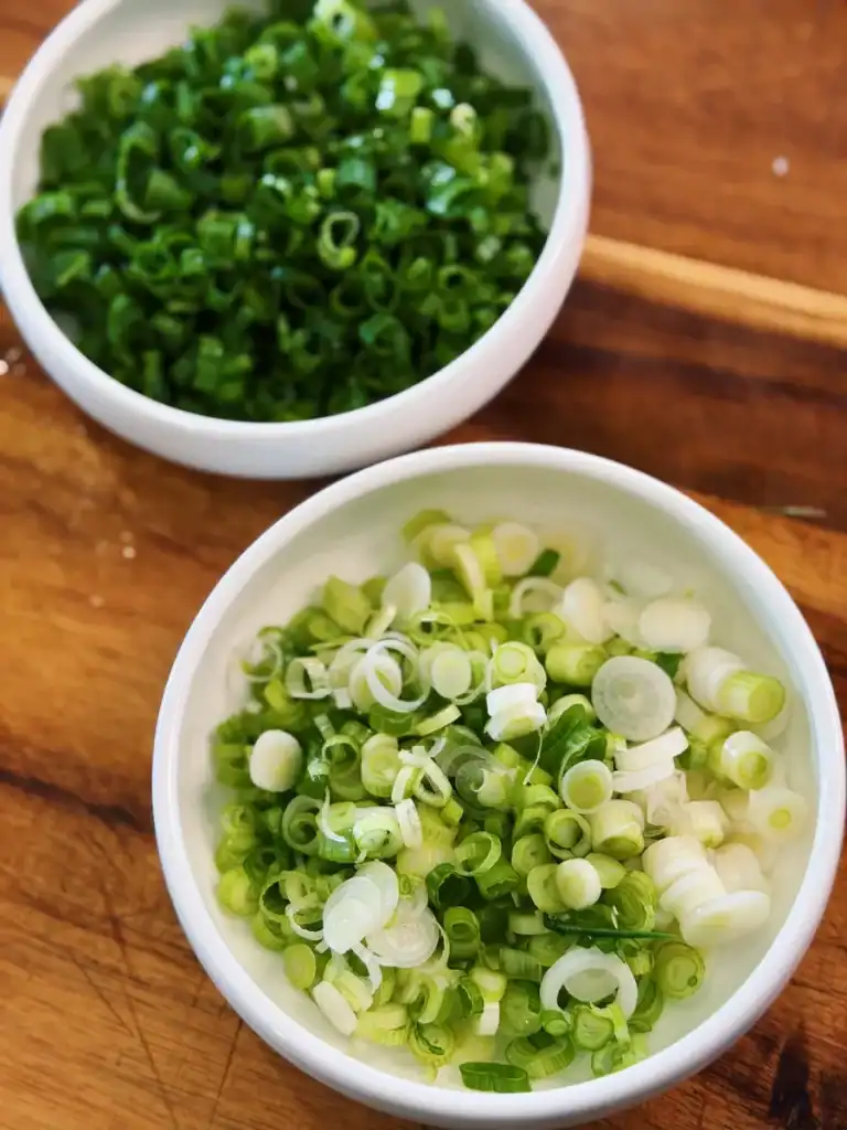 Chopped green onion with green and white parts separated. 