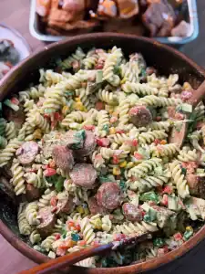 A big bowl of Southwestern Creamy Cilantro Loaded Chicken Pasta with roasted corn, chunks of chicken breast, sausages, various vegetables, and pasta