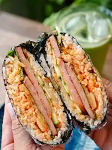 Cross section of a halved Spam Kimchi Onigirazu showing the layers of rice and fillings inside