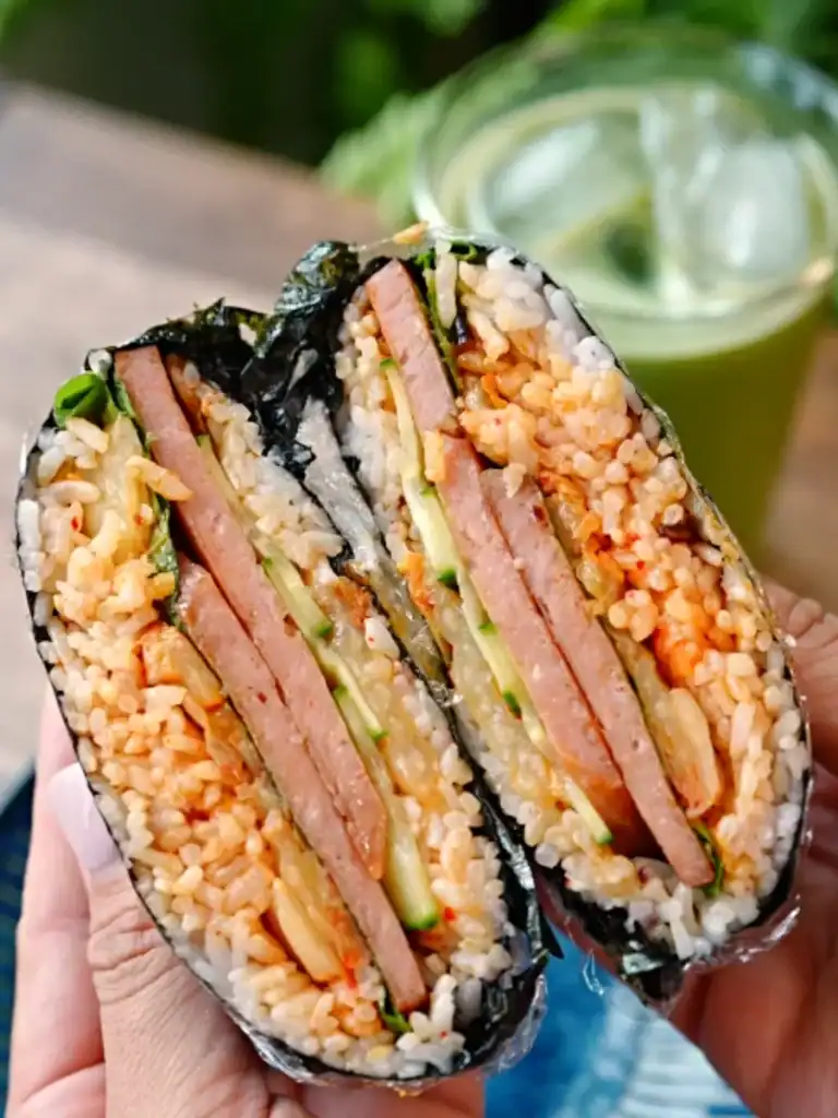 Cross section of a halved Spam Kimchi Onigirazu showing the layers of rice and fillings inside