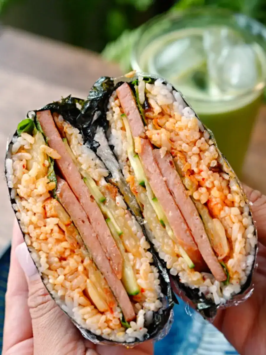 Cross section of a halved Spam Kimchi Onigirazu showing the layers of rice and fillings inside