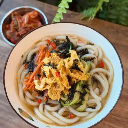 A bowl of Breakfast Vegetable Noodle Sou Served with fresh kimchi