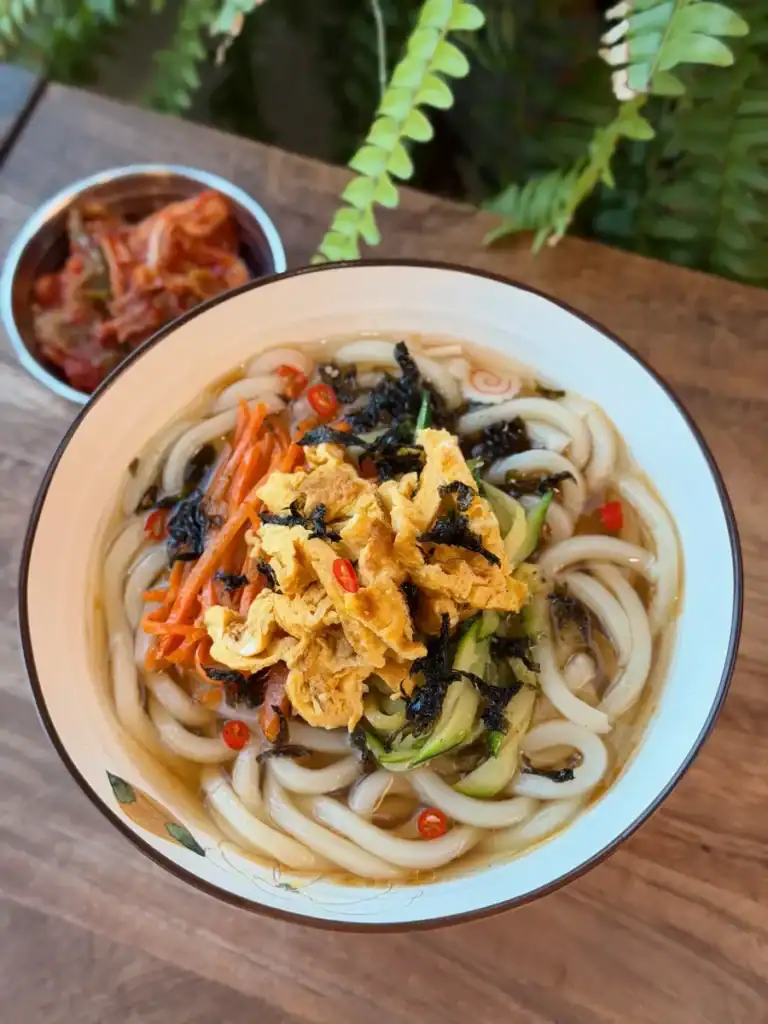 A bowl of Breakfast Vegetable Noodle Sou Served with fresh kimchi